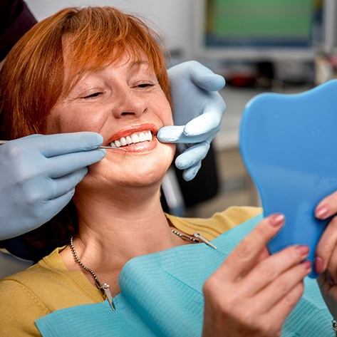 woman smiling after getting dental bridge