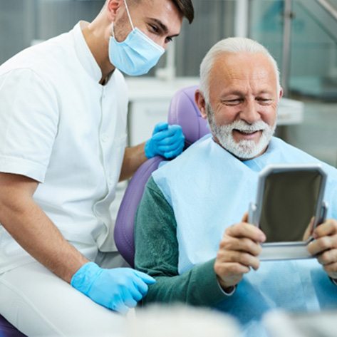 Man smiling at the dentist’s office after a root canal   