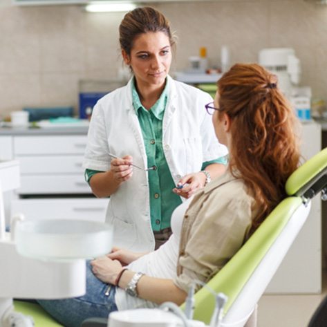 A dentist explaining the full mouth reconstruction process to her patient