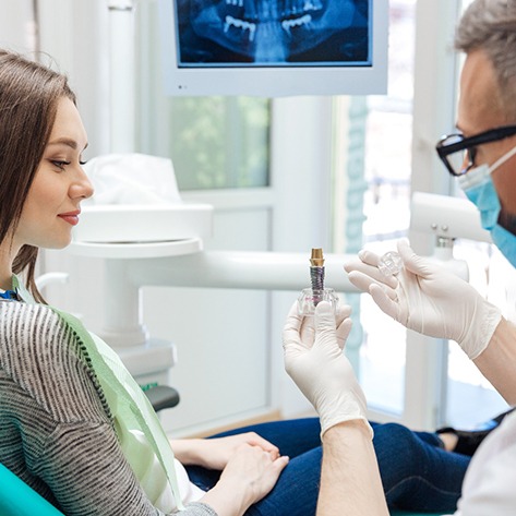 A dentist explaining dental implant care in West Loop
