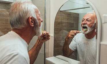 An elderly man brushing his teeth