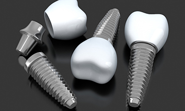 three dental implant posts with abutments and crowns 
