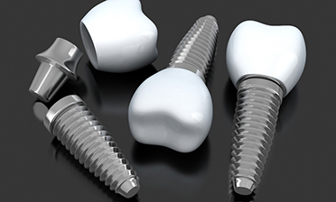 three dental implant posts with abutments and crowns