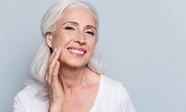 smiling senior woman touching her face