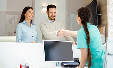 dental team member shaking hands with patient