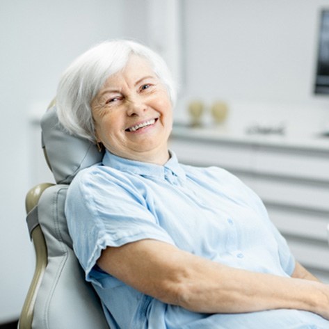 Senior woman sitting and smiling in dental chair