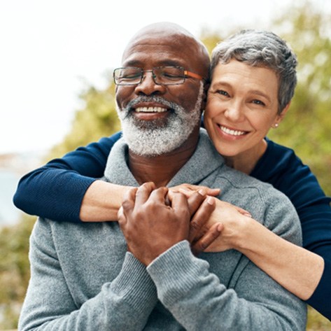 Senior man and woman outside and smiling