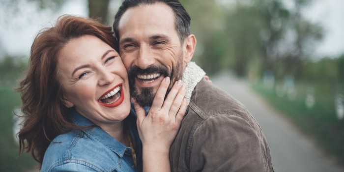 Smiling older man and woman holding each other outdoors