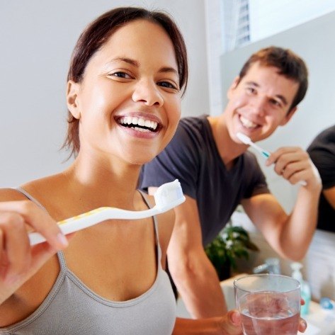 Man and woman brushing teeth together