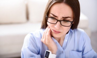 Woman in need fo T M J therapy holding jaw