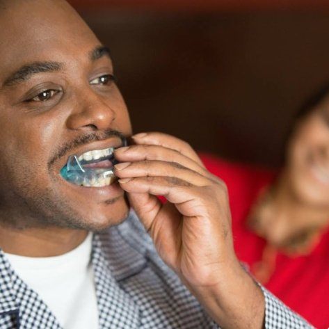 Man placing an oral appliance for sleep apnea therapy