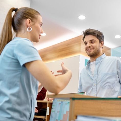 a patient asking front desk about the cost of veneers