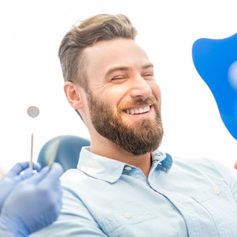 dental patient seeing his new smile with veneers 