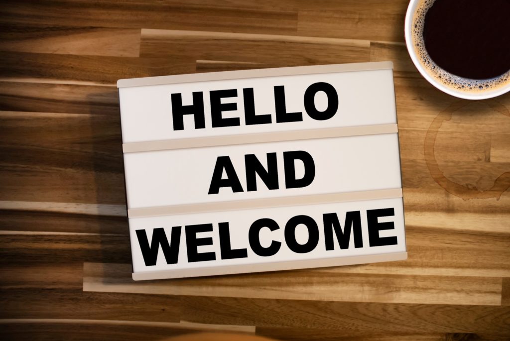 Hello and welcome letterboard on table with coffee