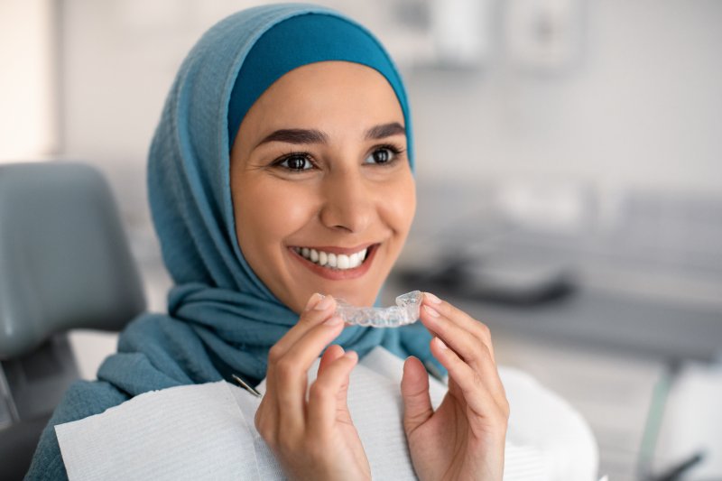 Woman smiling as she's about to use Invisalign for the first time