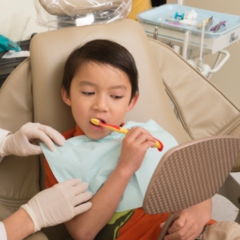 Young patient receiving treatment during children's dentistry checkup and teeth cleaning visit